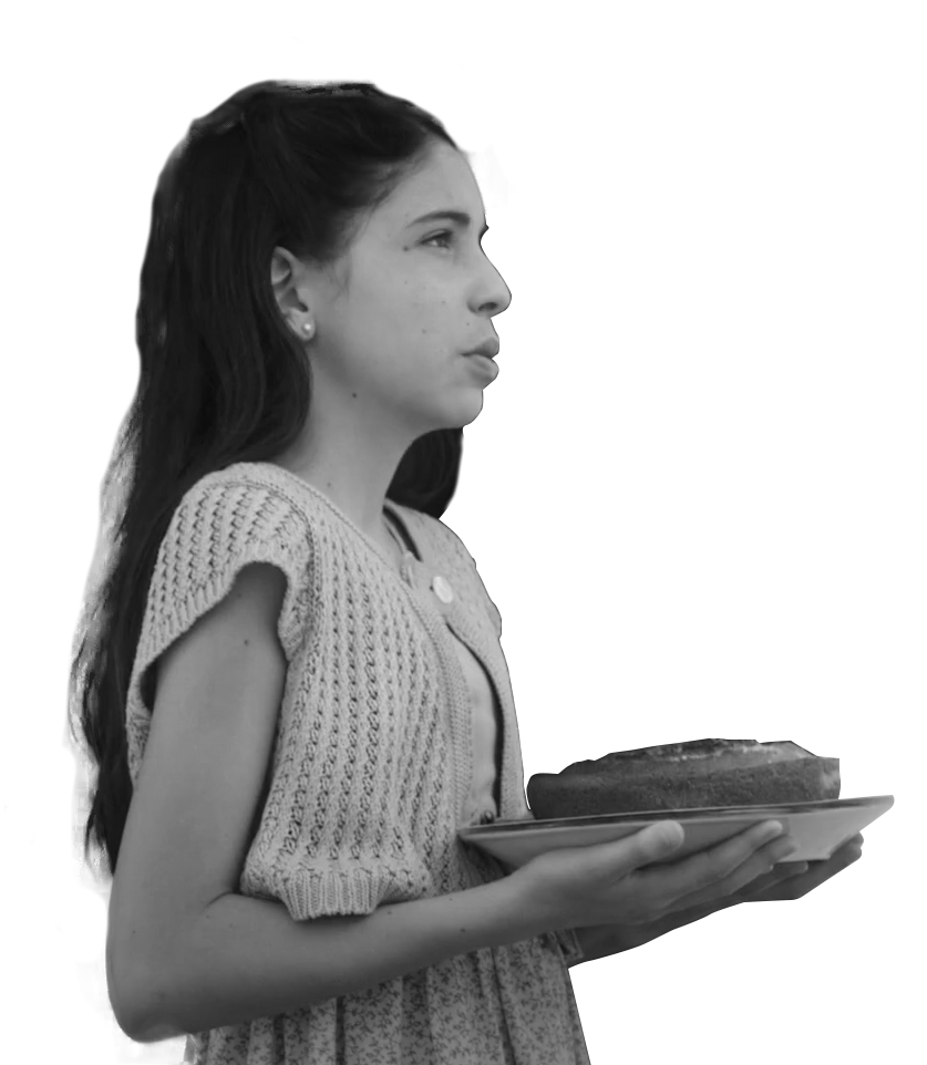 Imagem em preto e branco de garota branca, com cabelos longos e escuros, segurando um prato com um bolo.