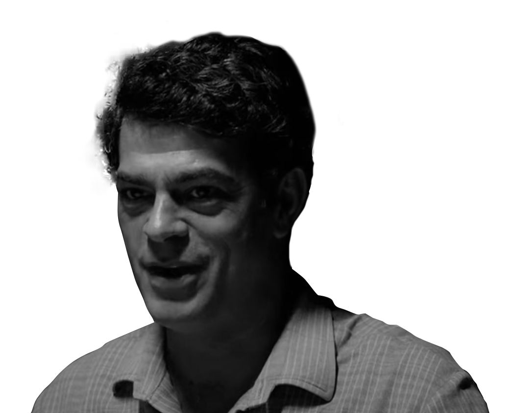 Imagem em preto e branco de perfil de homem pardo, sem barba, com cabelos escuros, vestindo uma camisa listrada.